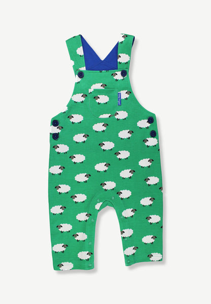 Green baby overalls with a white sheep pattern, featuring a blue V-neck interior and shoulder straps, shown flat on a light gray background.