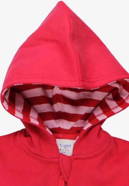 A close-up of a bright red children's hooded sweatshirt with a striped red and white inner hood lining. A white brand label reading 'tiger MAMIC' is visible at the collar.
