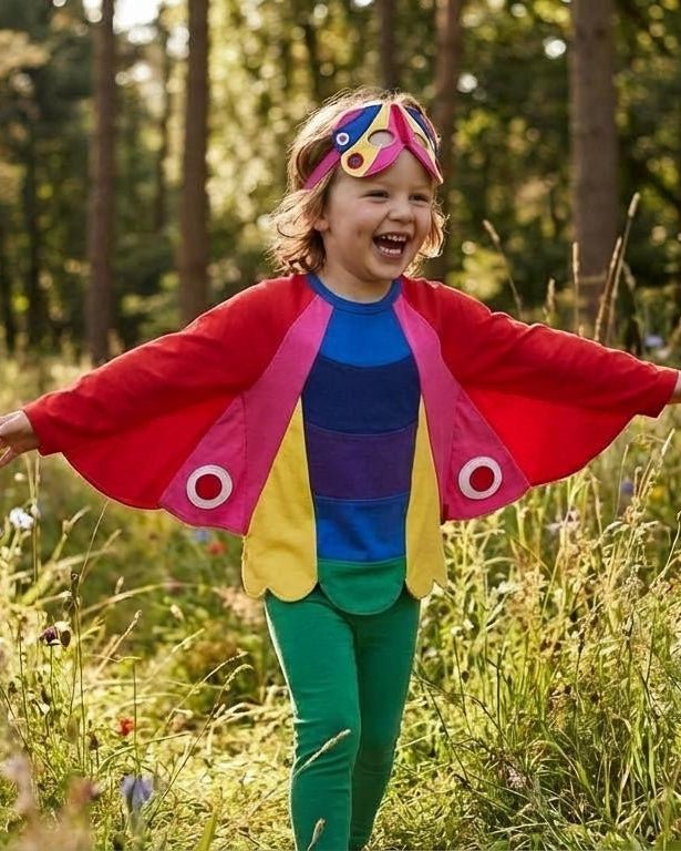 Child in colorful outfit with butterfly wings in a forest