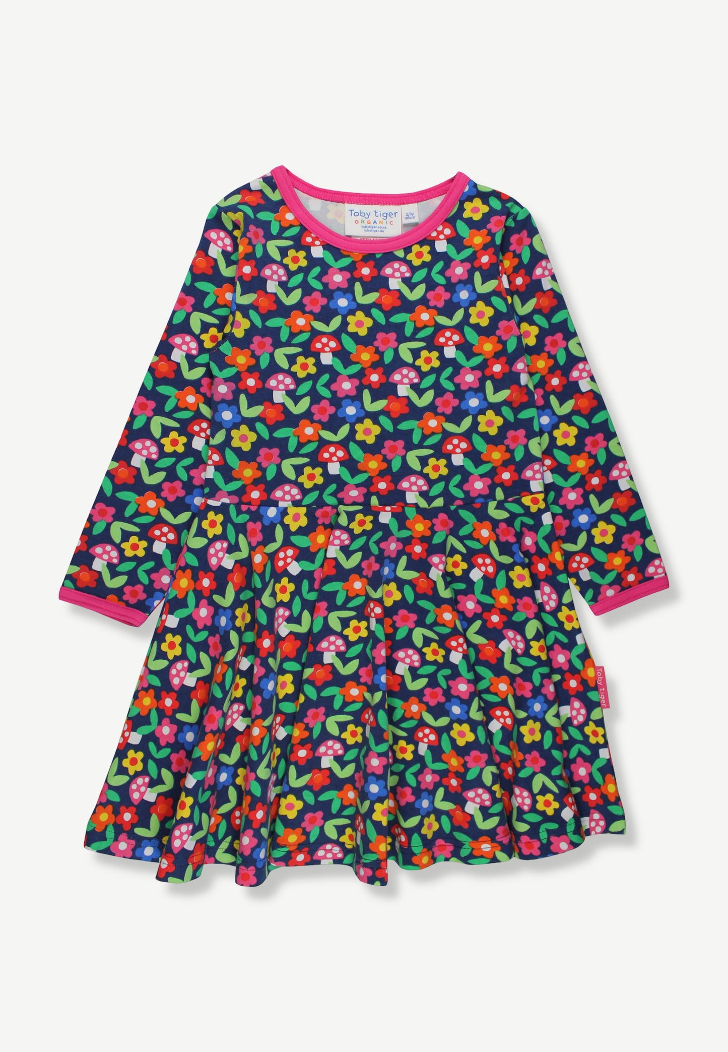 A long-sleeve tiered dress for toddlers or young girls, featuring a dense multicolor floral print on a dark green background with bright pink, red, yellow, and blue flowers, finished with a contrasting pink collar and cuffs.