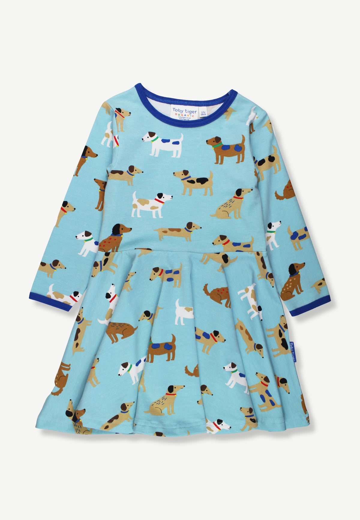 A light blue long-sleeve dress for toddlers, featuring an all-over playful print of various dog illustrations. The dress has a pleated skirt and is finished with contrasting dark blue trim at the crew neck and cuffs.