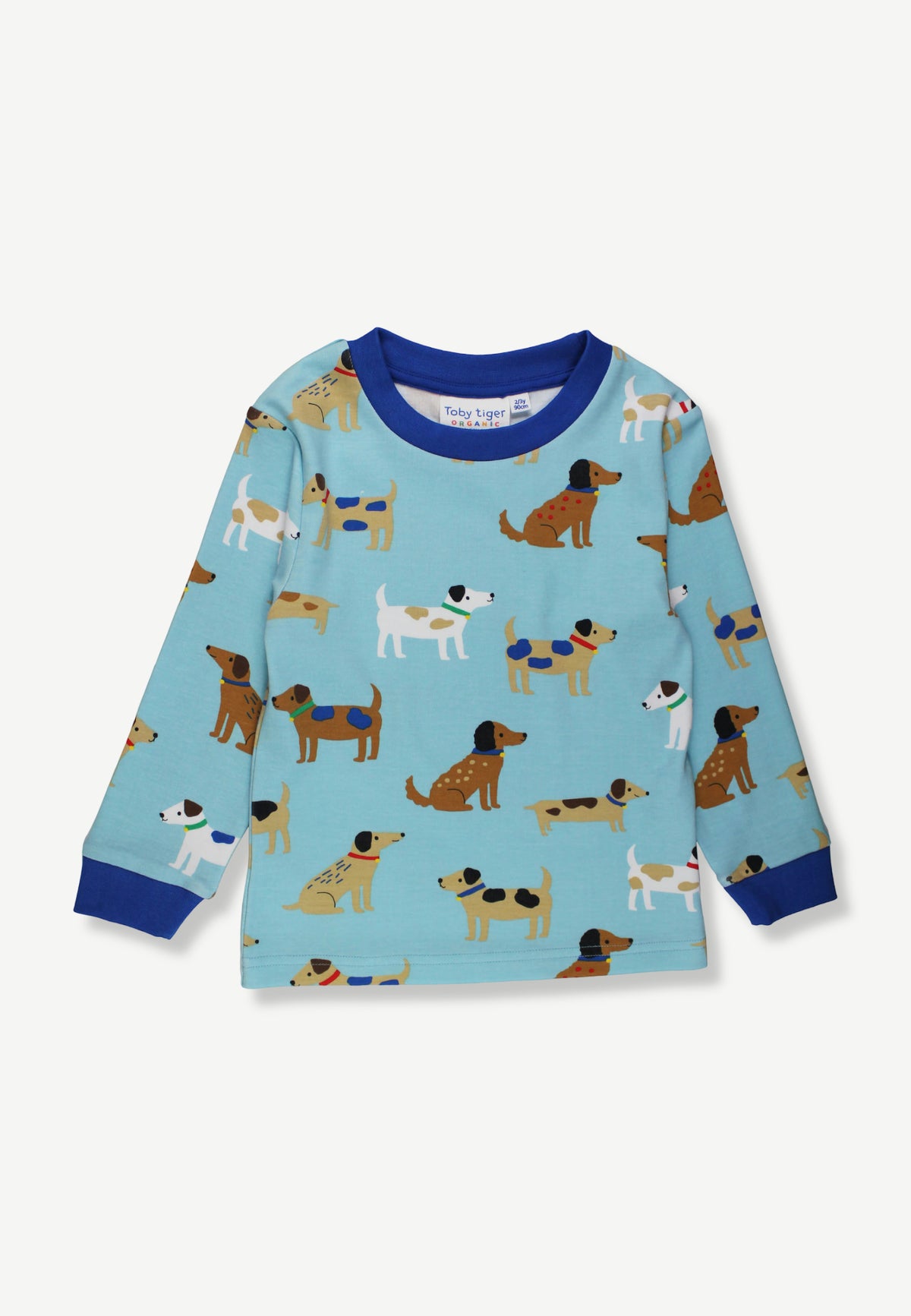 A toddler's long-sleeve pajama top in light blue, featuring an all-over print of cartoon dogs in various breeds and colors, with a solid dark blue crew neck, cuffs, and hem.