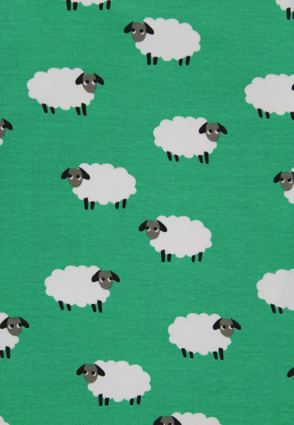 A repeating pattern of cartoon sheep on a bright green background. Each sheep has a white body, a dark gray head, and small black legs.
