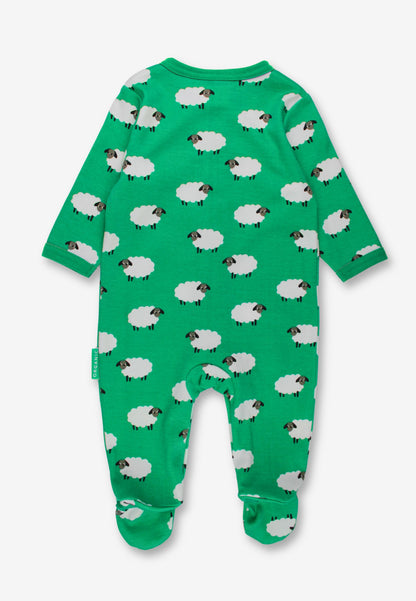 A green baby footed sleeper with an all-over sheep print, shown flat against a light gray background.