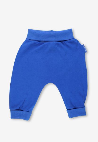 A pair of bright royal blue baby pants with a wide elastic waistband and cuffed ankles, shown flat on a light gray background.