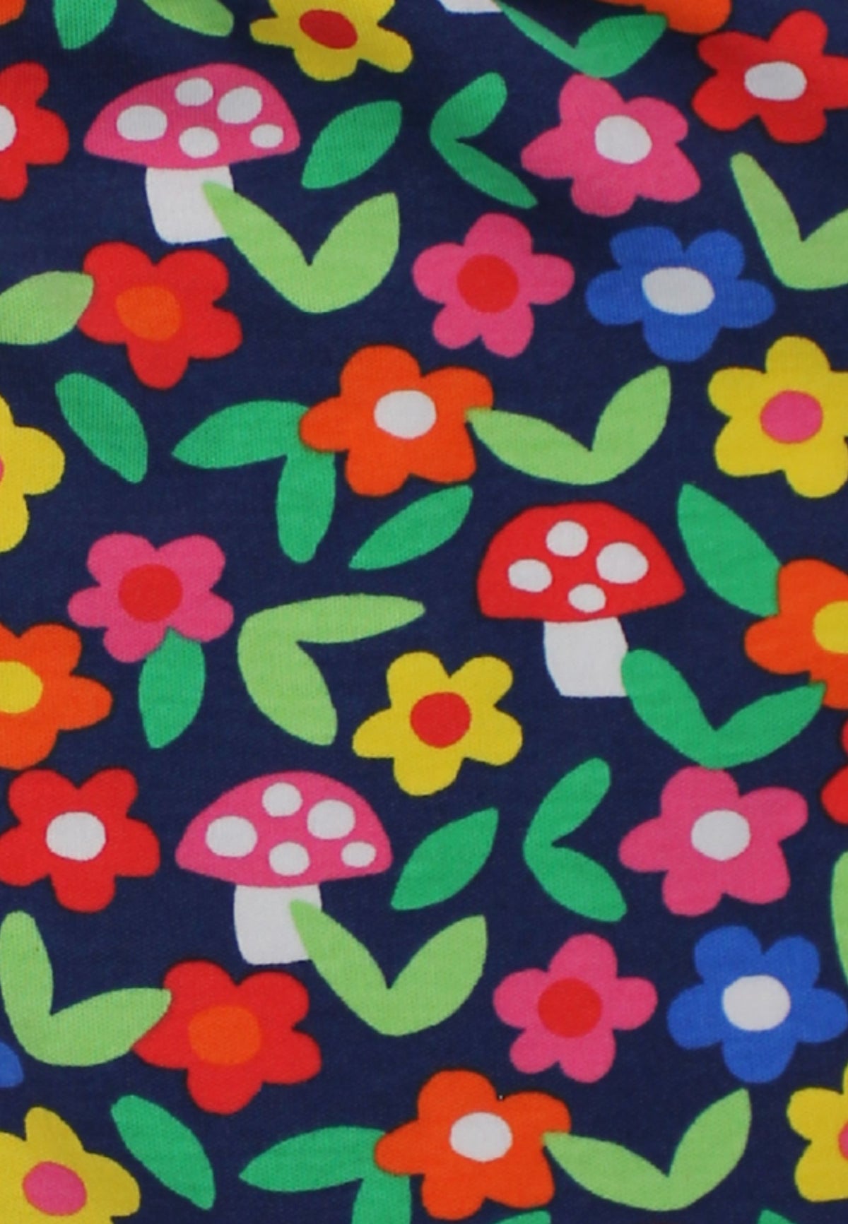 A close-up of a fabric pattern featuring colorful flowers and red-and-white mushrooms on a dark navy blue background.