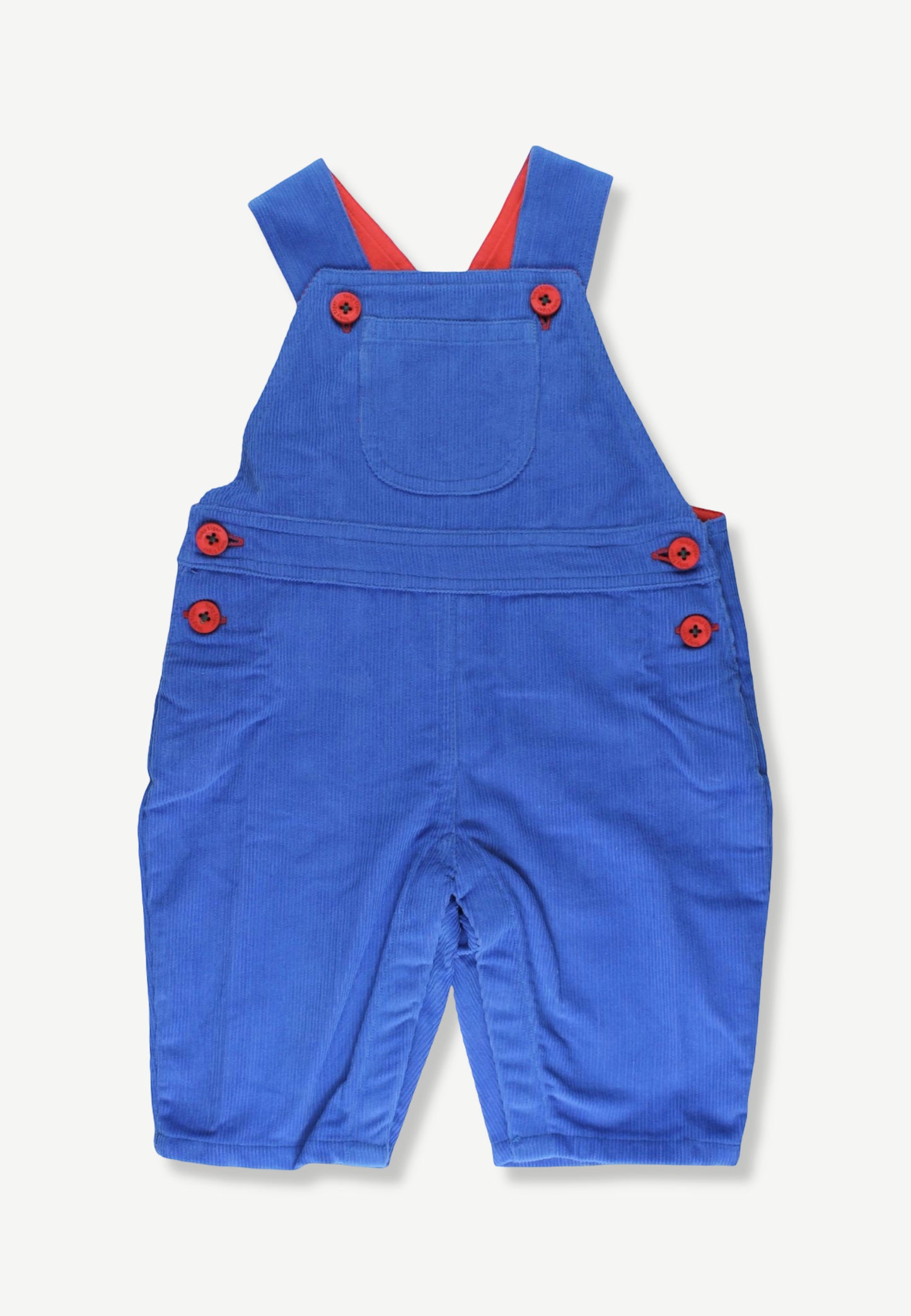 A pair of blue corduroy baby overalls with red buttons and red inner shoulder straps, laid flat on a light off-white background.