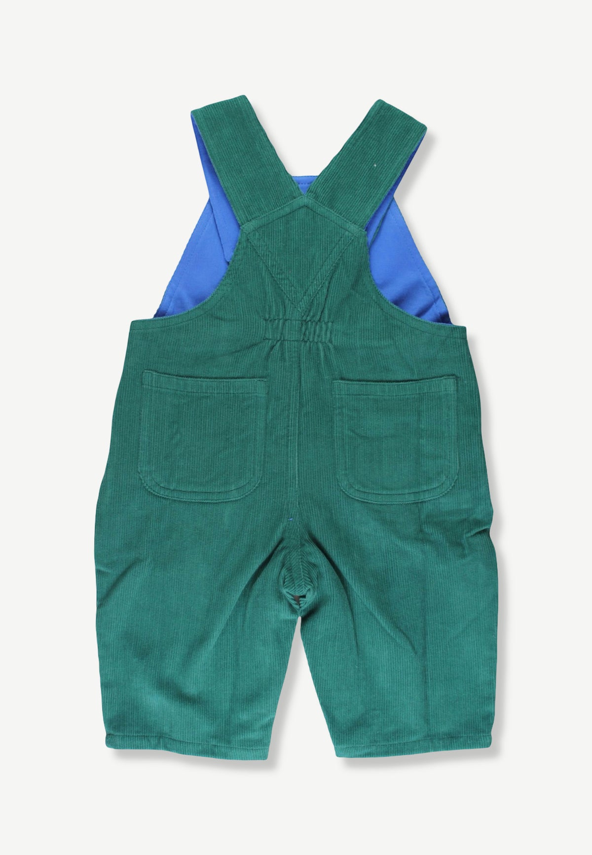 A pair of green corduroy baby overalls shown from the back, featuring a bright blue shirt peeking out from underneath, set against a plain off-white background.